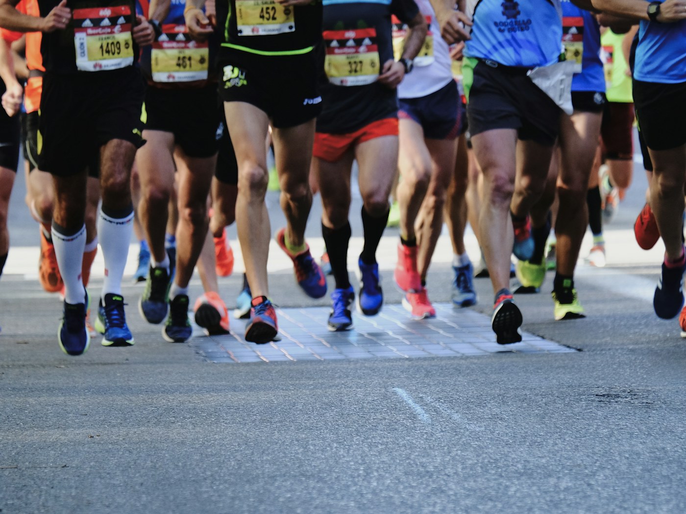 Participantes corriendo en una carrera popular sobre asfalto